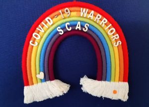 Handmade rainbow with the words covid-19 warriors SCAS